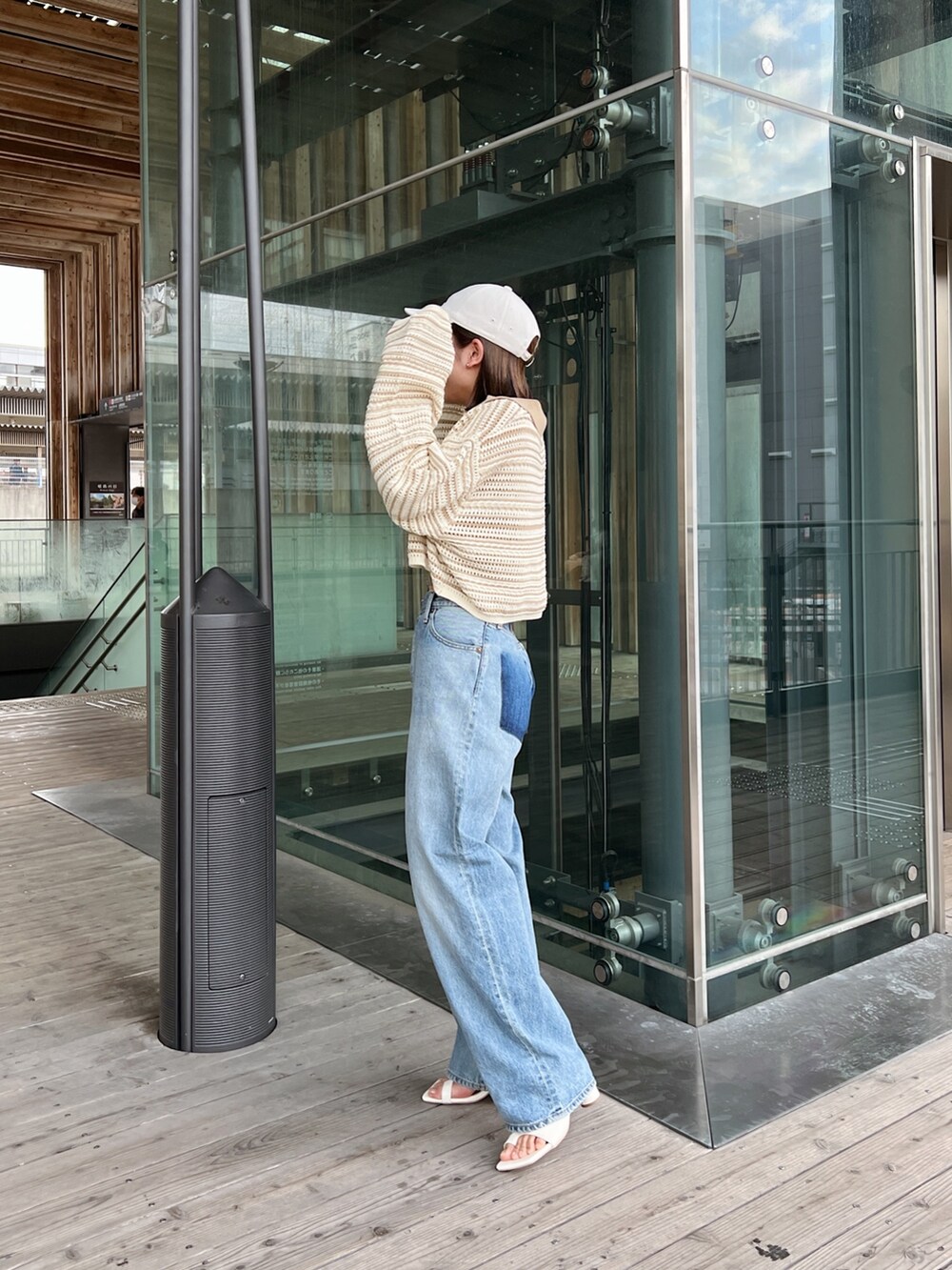 ベージュ系のニット/セーター、ブルー系のデニムパンツ、ホワイト系のサンダルを着用したレディースの春コーディネートの5枚目の写真