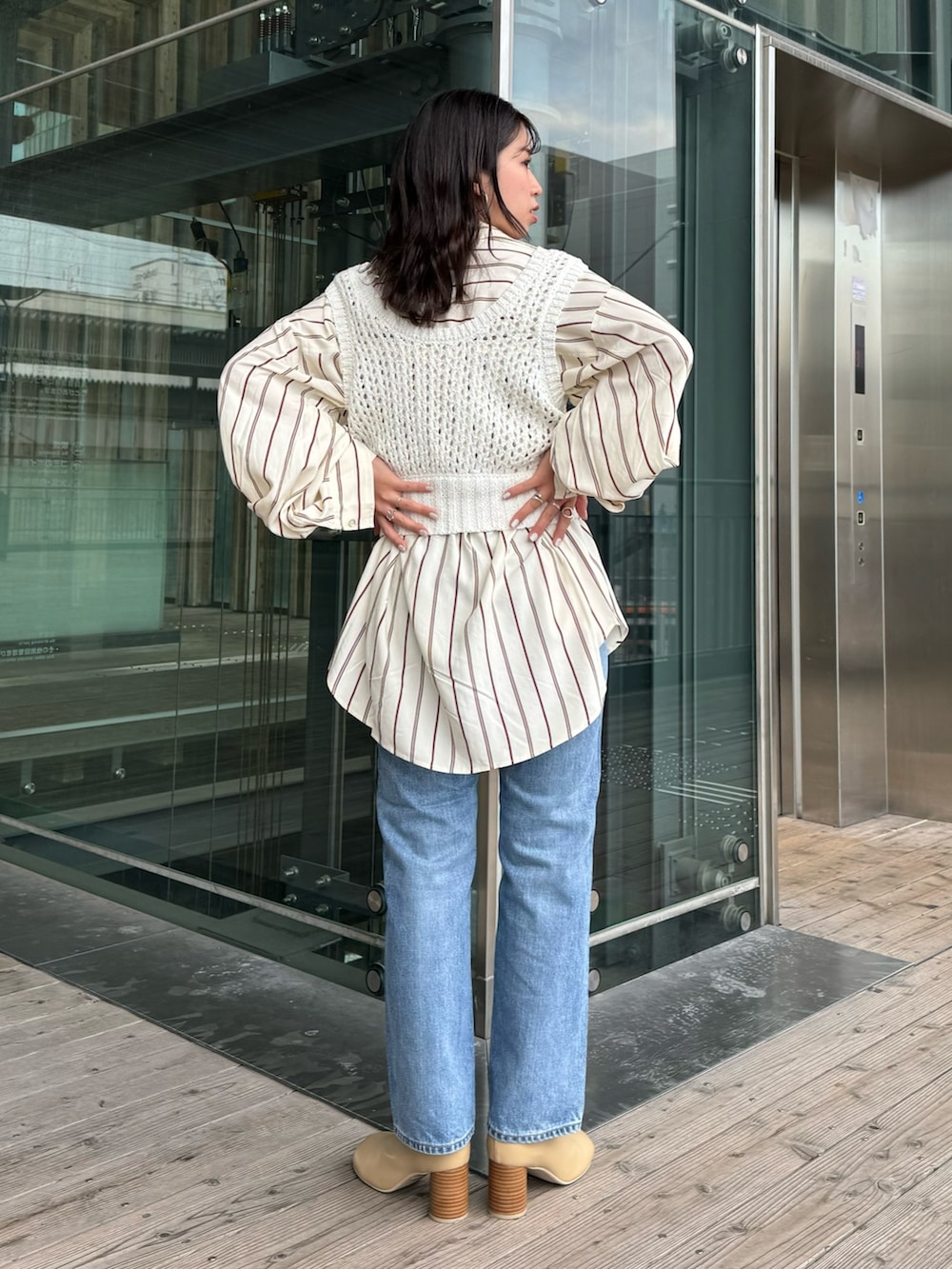 ベージュ系のブーツ、ブルー系のデニムパンツ、イエロー系のシャツ/ブラウスを着用したレディースの冬コーディネートの5枚目の写真