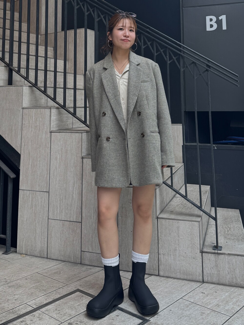 グレー系のスカート、ホワイト系のシャツ/ブラウス、グレー系のテーラードジャケットを着用したレディースの秋コーディネートの3枚目の写真