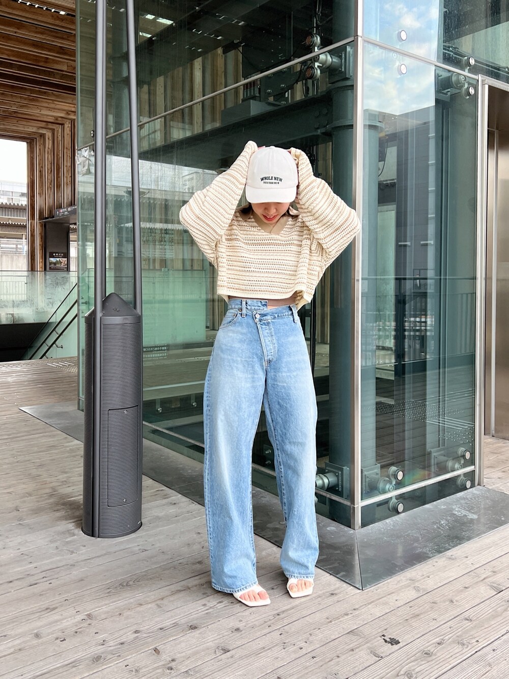 ベージュ系のニット/セーター、ブルー系のデニムパンツ、ホワイト系のサンダルを着用したレディースの春コーディネートの4枚目の写真