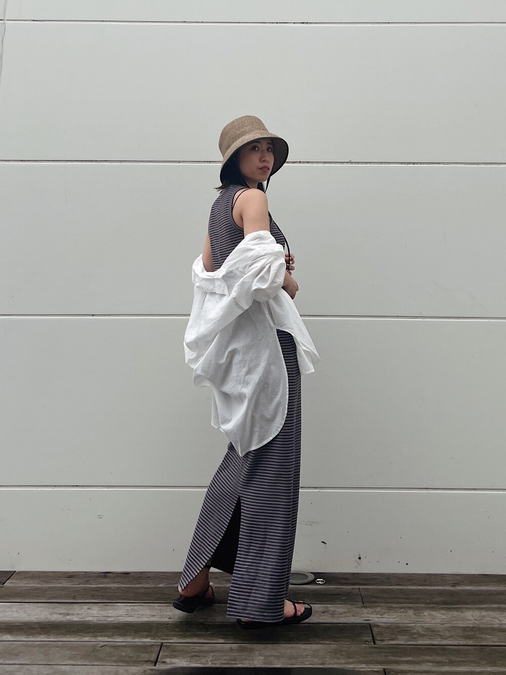 ホワイト系のシャツ/ブラウス、ブラック系のサンダル、ブルー系のワンピースを着用したレディースの春コーディネートの2枚目の写真