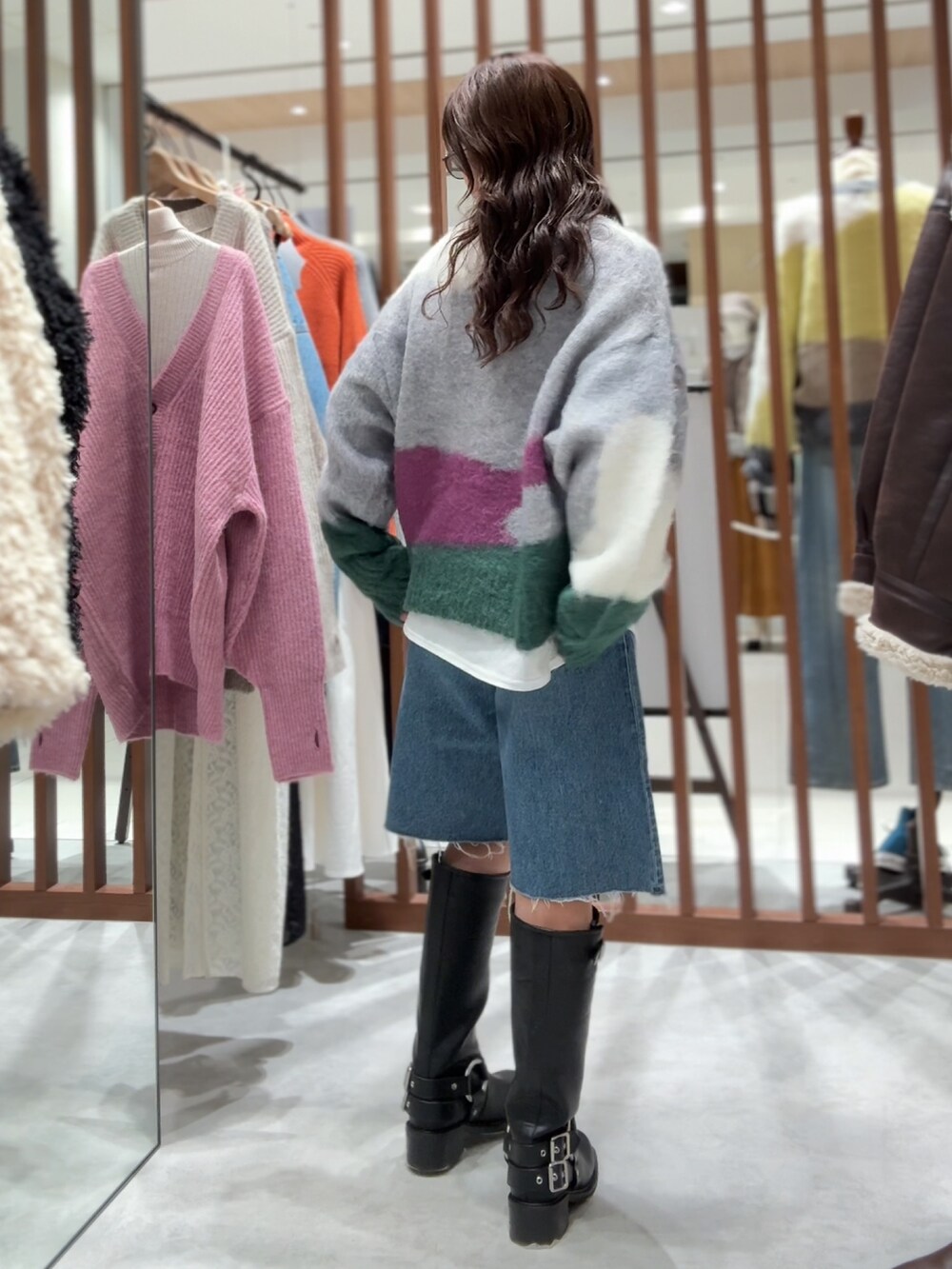 グリーン系のニット/セーター、ホワイト系のTシャツ/カットソー、ブルー系のデニムパンツを着用したレディースの秋コーディネートの7枚目の写真