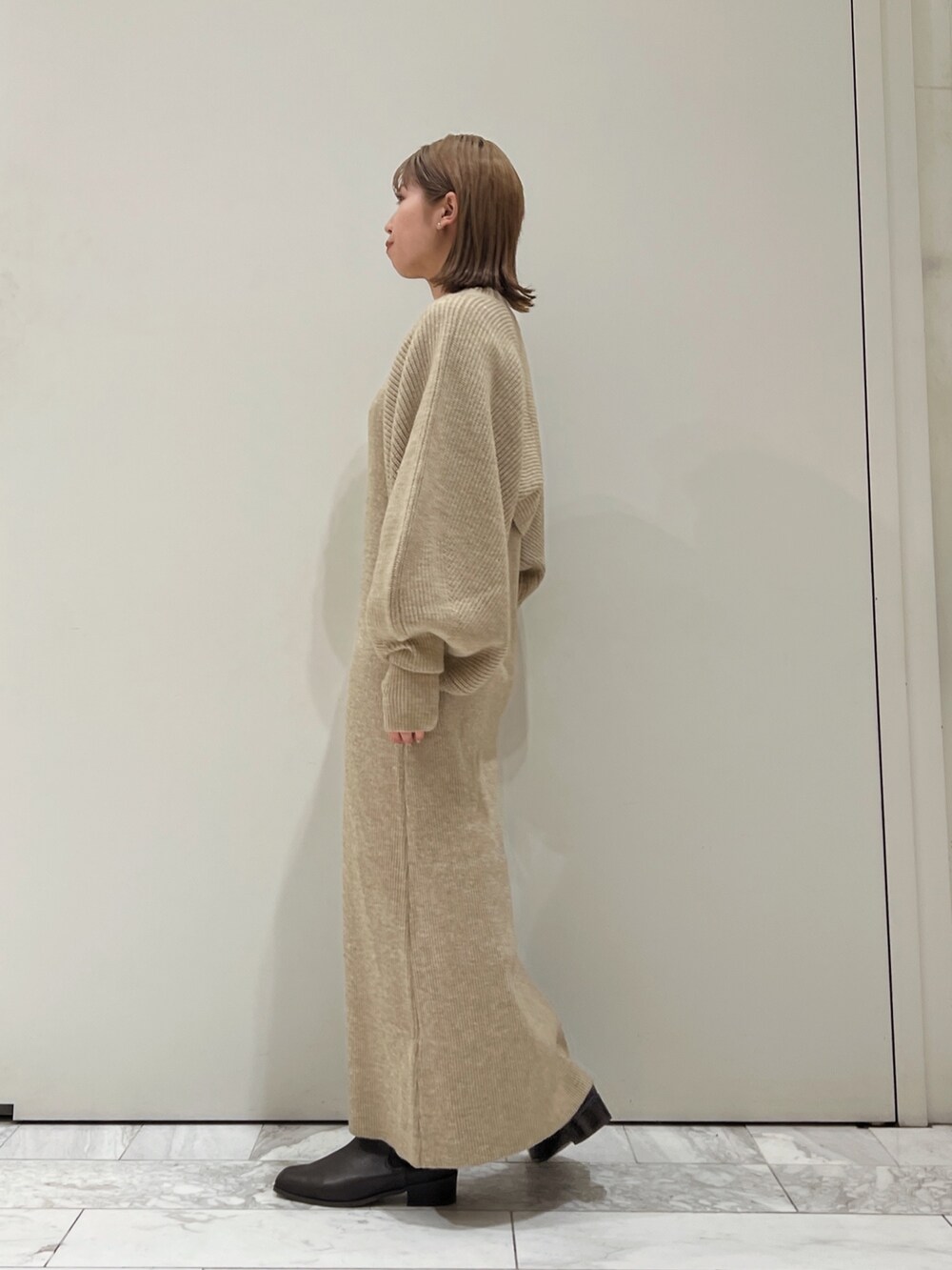 グレー系のワンピース、ブラウン系のブーツを着用したレディースの秋コーディネートの7枚目の写真