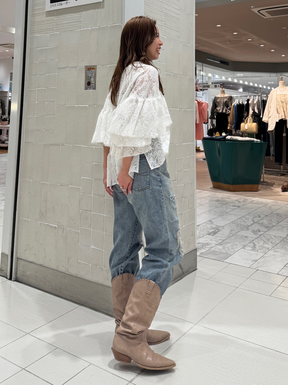 ブルー系のデニムパンツ、ホワイト系のシャツ/ブラウス、ベージュ系のブーツを着用したレディースの春コーディネートの2枚目の写真