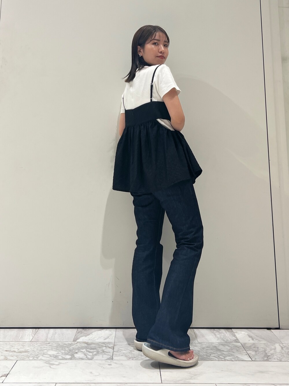 ブルー系のデニムパンツ、ブラック系のキャミソール、ホワイト系のTシャツ/カットソーを着用したレディースの夏コーディネートの3枚目の写真