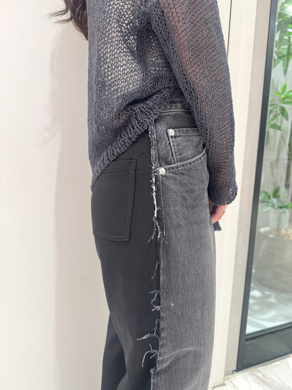 ブラック系のデニムパンツ、グレー系のニット/セーター、ブラック系のサンダルを着用したレディースの秋コーディネートの7枚目の写真