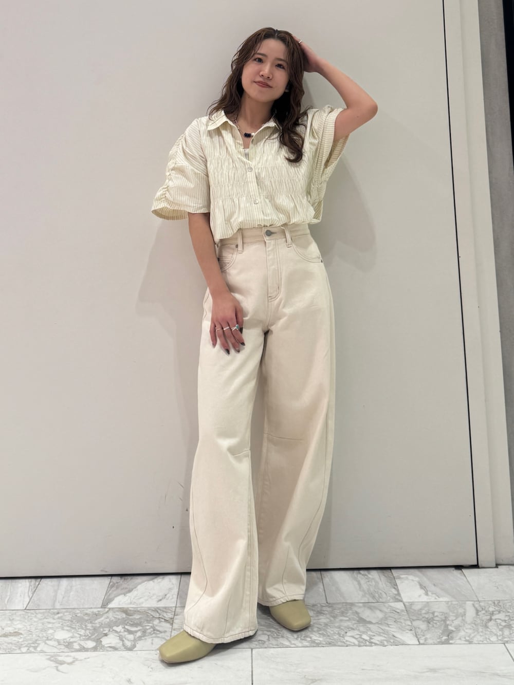 ホワイト系のデニムパンツ、イエロー系のシャツ/ブラウス、イエロー系のサンダルを着用したレディースの春コーディネートの2枚目の写真