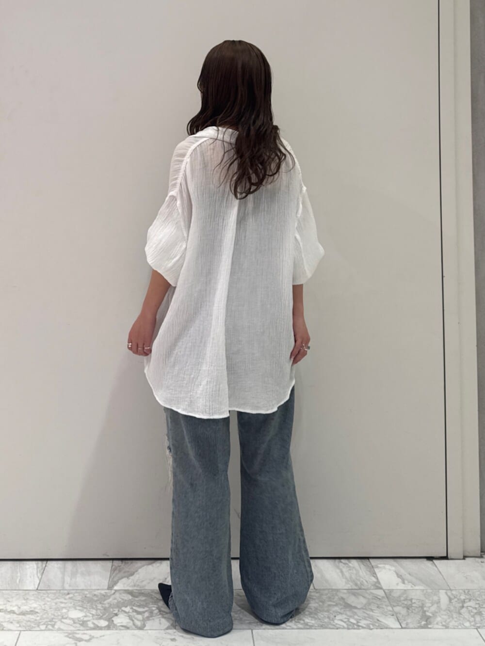 ブラック系のパンプス、ホワイト系のシャツ/ブラウス、ブルー系のデニムパンツを着用したレディースの春コーディネートの6枚目の写真