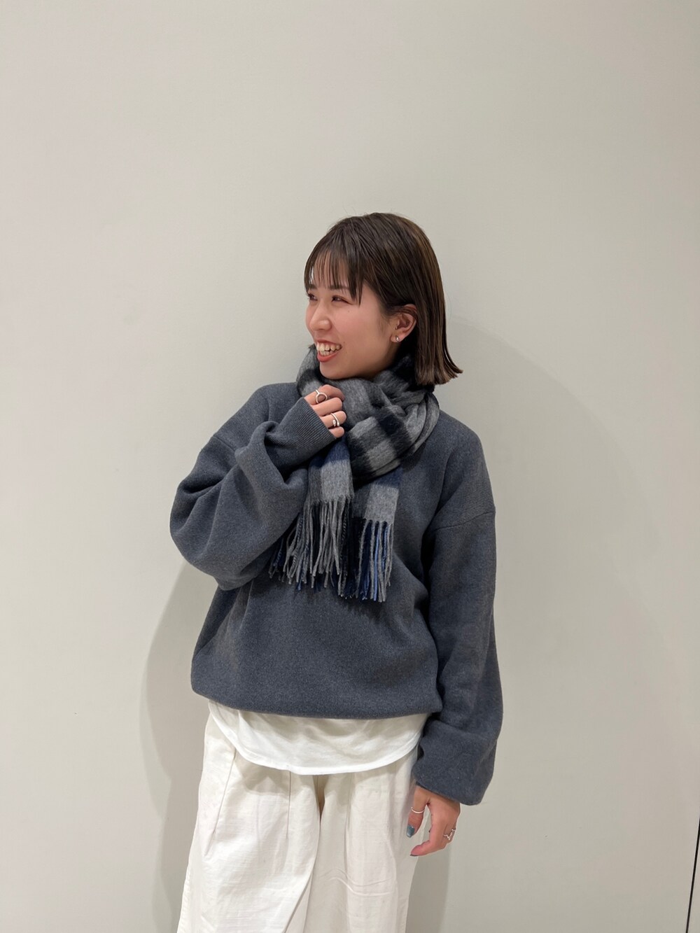 グレー系のニット/セーター、ホワイト系のTシャツ/カットソー、ホワイト系のその他パンツを着用したレディースの冬コーディネートの5枚目の写真