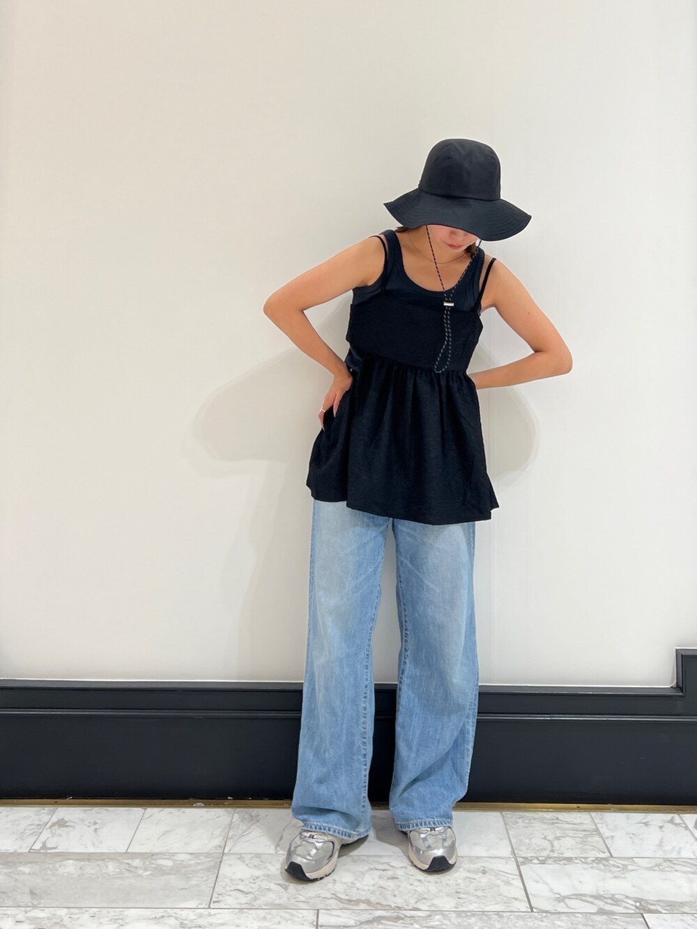 グレー系のタンクトップ、ブルー系のデニムパンツ、ブラック系のシャツ/ブラウスを着用したレディースの春コーディネートの2枚目の写真