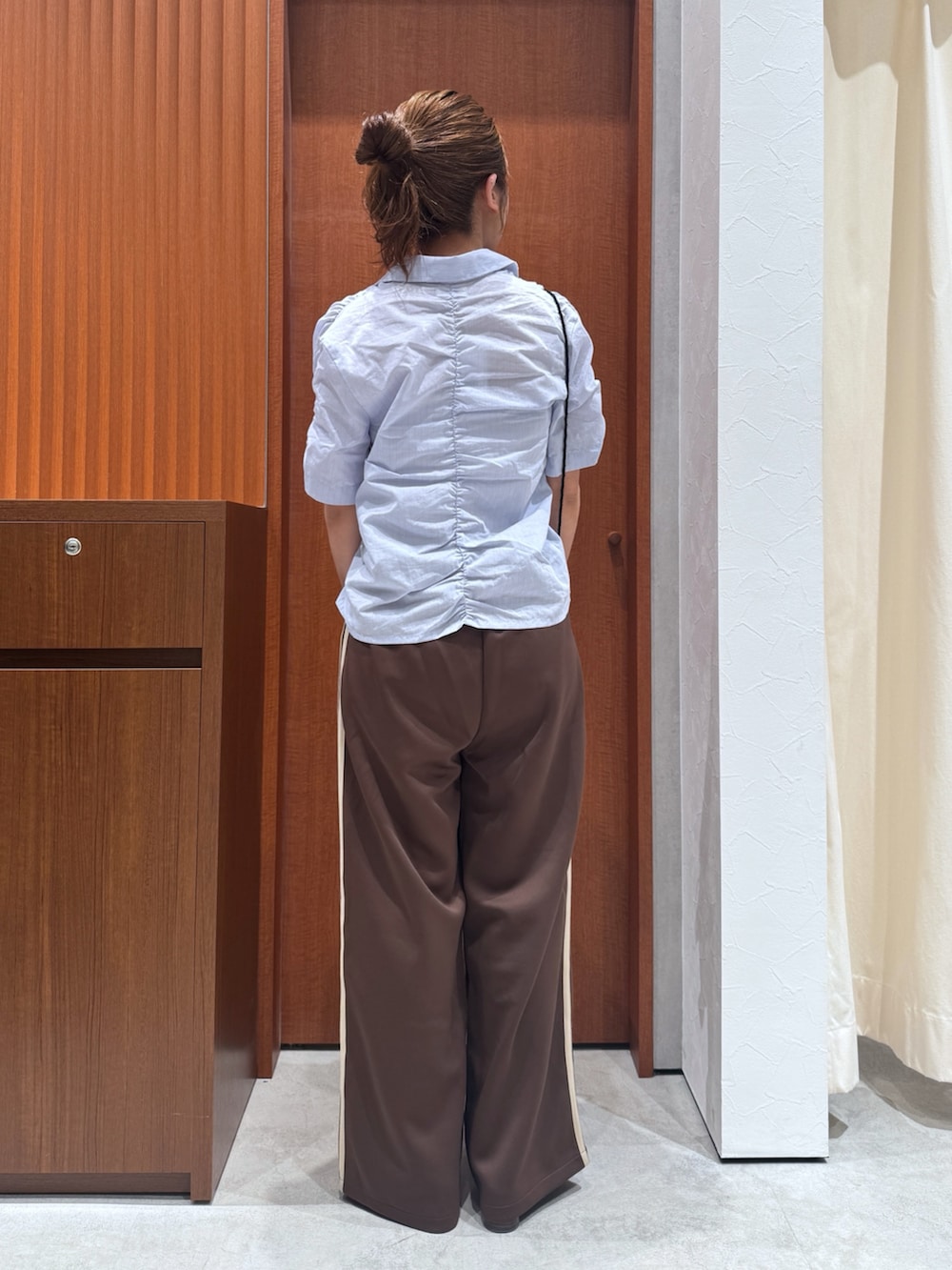 ブラウン系のその他パンツ、ブルー系のシャツ/ブラウス、ブラック系のハンドバッグを着用したレディースの夏コーディネートの3枚目の写真