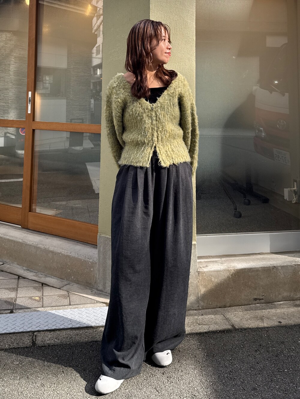 グレー系のその他パンツ、イエロー系のニット/セーターを着用したレディースの秋コーディネートの2枚目の写真