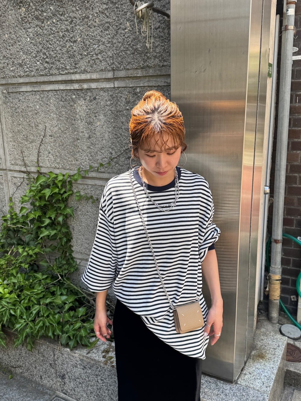 ブルー系のTシャツ/カットソー、ブラック系のスカート、ブラック系のスリッポンを着用したレディースの夏コーディネートの6枚目の写真