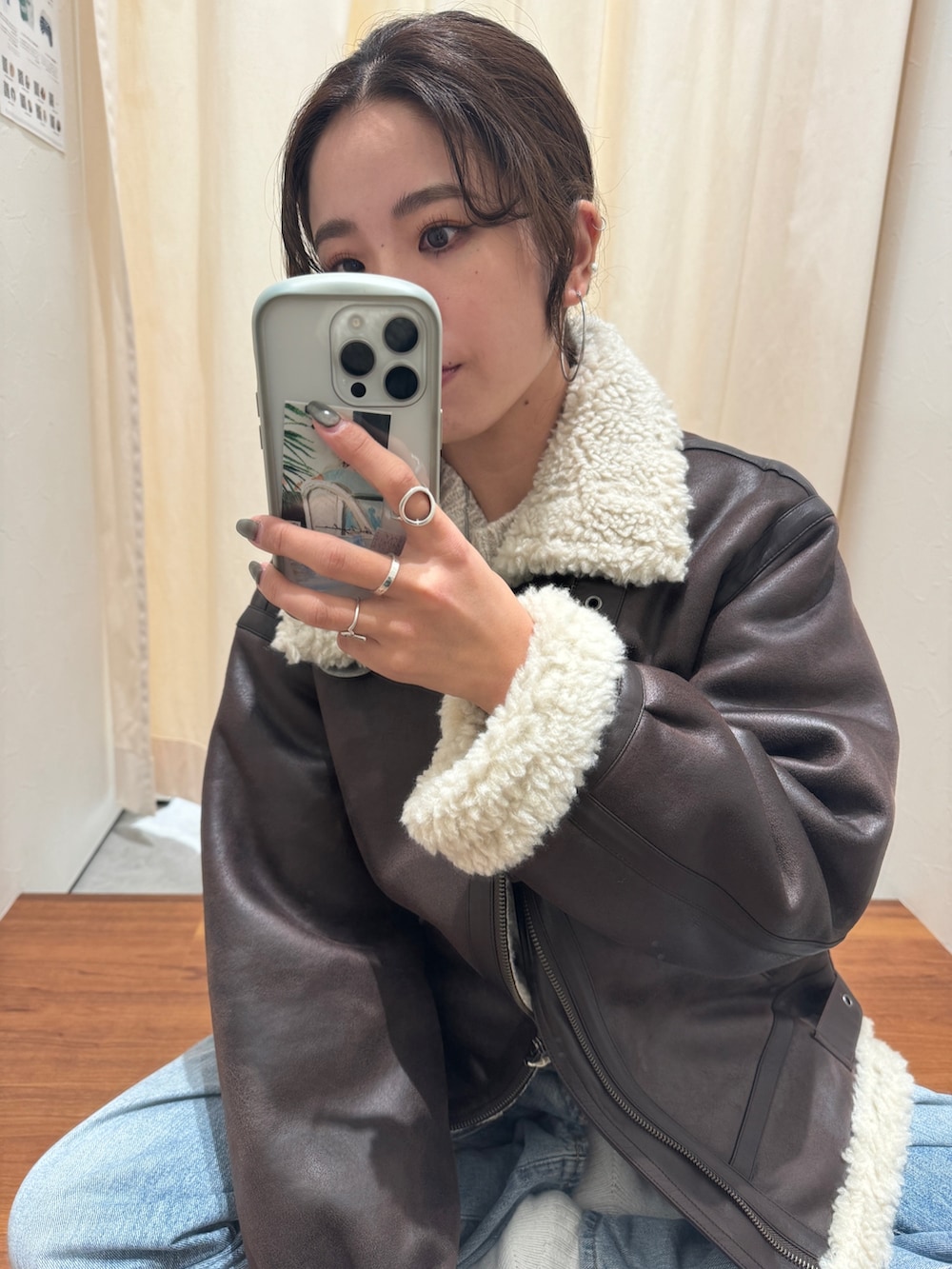 ブルー系のデニムパンツ、ブラウン系のブルゾン、ホワイト系のニット/セーターを着用したレディースの秋コーディネートの6枚目の写真