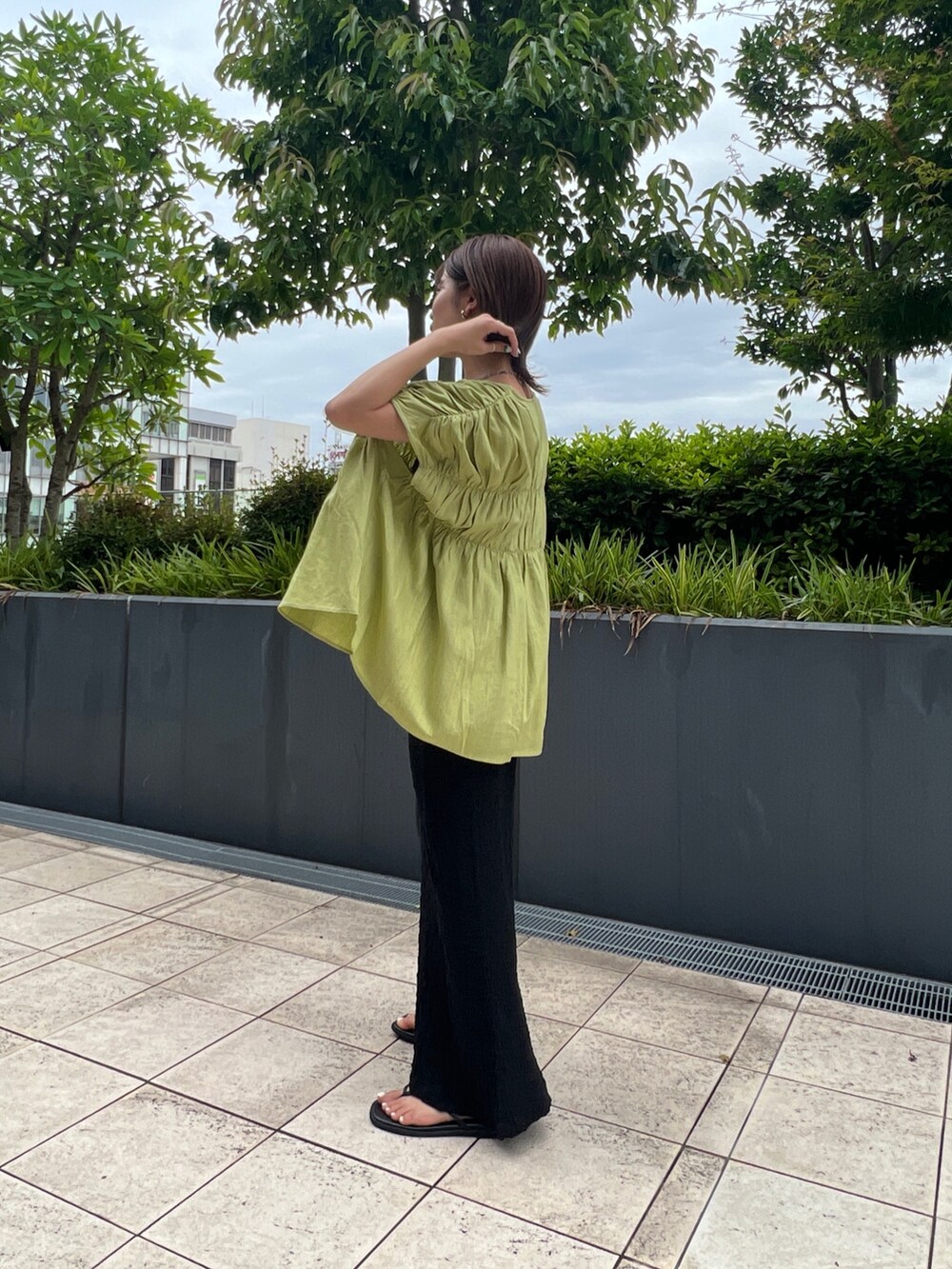 グリーン系のシャツ/ブラウス、ブラック系のスカート、ブラック系のサンダルを着用したレディースの夏コーディネートの2枚目の写真