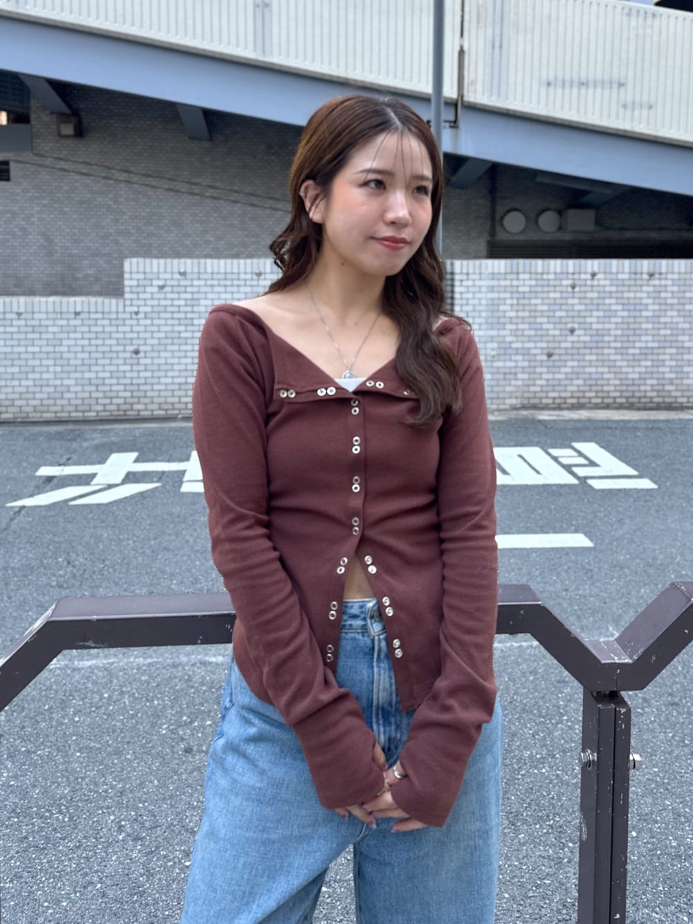 ブルー系のデニムパンツ、ブラウン系のTシャツ/カットソー、ブラウン系のブーツを着用したレディースの秋コーディネートの6枚目の写真