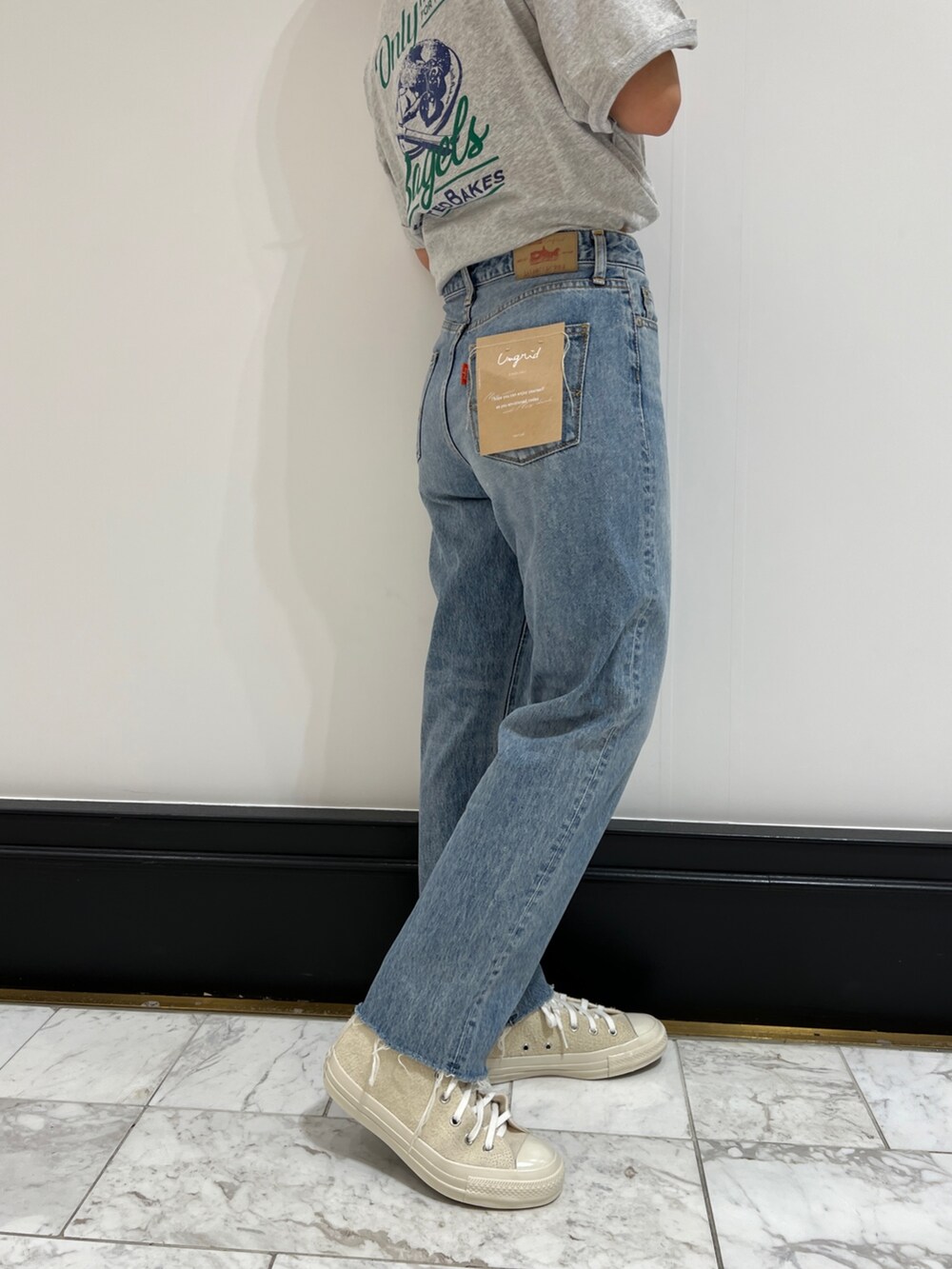 ブルー系のデニムパンツ、グレー系のTシャツ/カットソー、ホワイト系のスニーカーを着用したレディースの春コーディネートの10枚目の写真