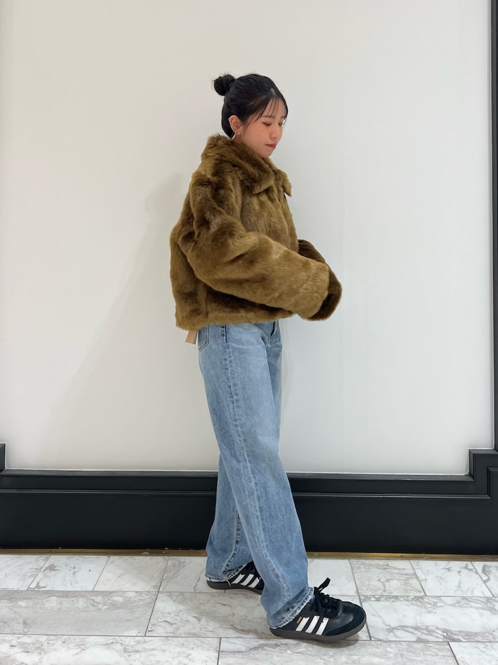 ブルー系のデニムパンツ、ブラウン系のブルゾン、レッド系のニット/セーターを着用したレディースの冬コーディネートの7枚目の写真