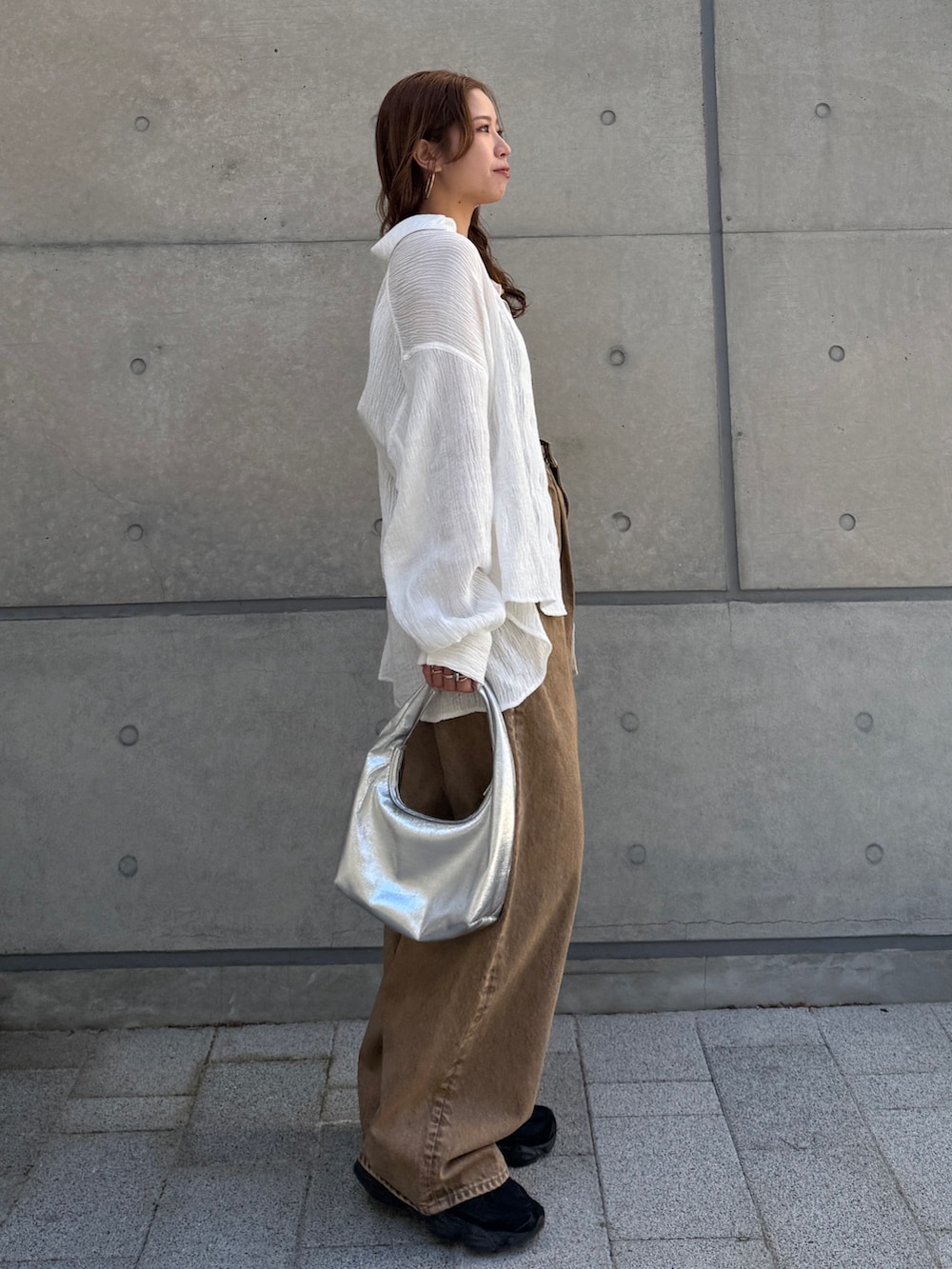 ブラウン系のデニムパンツ、ホワイト系のシャツ/ブラウスを着用したレディースの春コーディネートの6枚目の写真