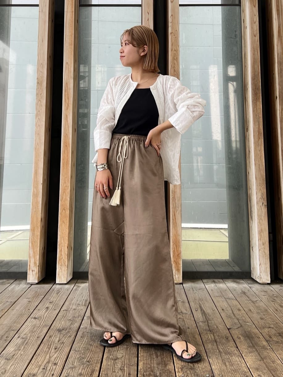 ホワイト系のシャツ/ブラウス、ブラック系のサンダル、ブラウン系のその他パンツを着用したレディースの春コーディネートの2枚目の写真