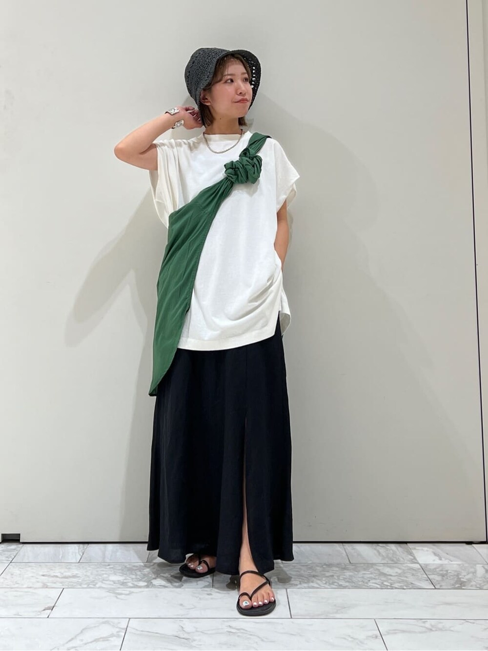 ブラック系のサンダル、ホワイト系のTシャツ/カットソー、グリーン系のシャツ/ブラウスを着用したレディースの夏コーディネートの6枚目の写真