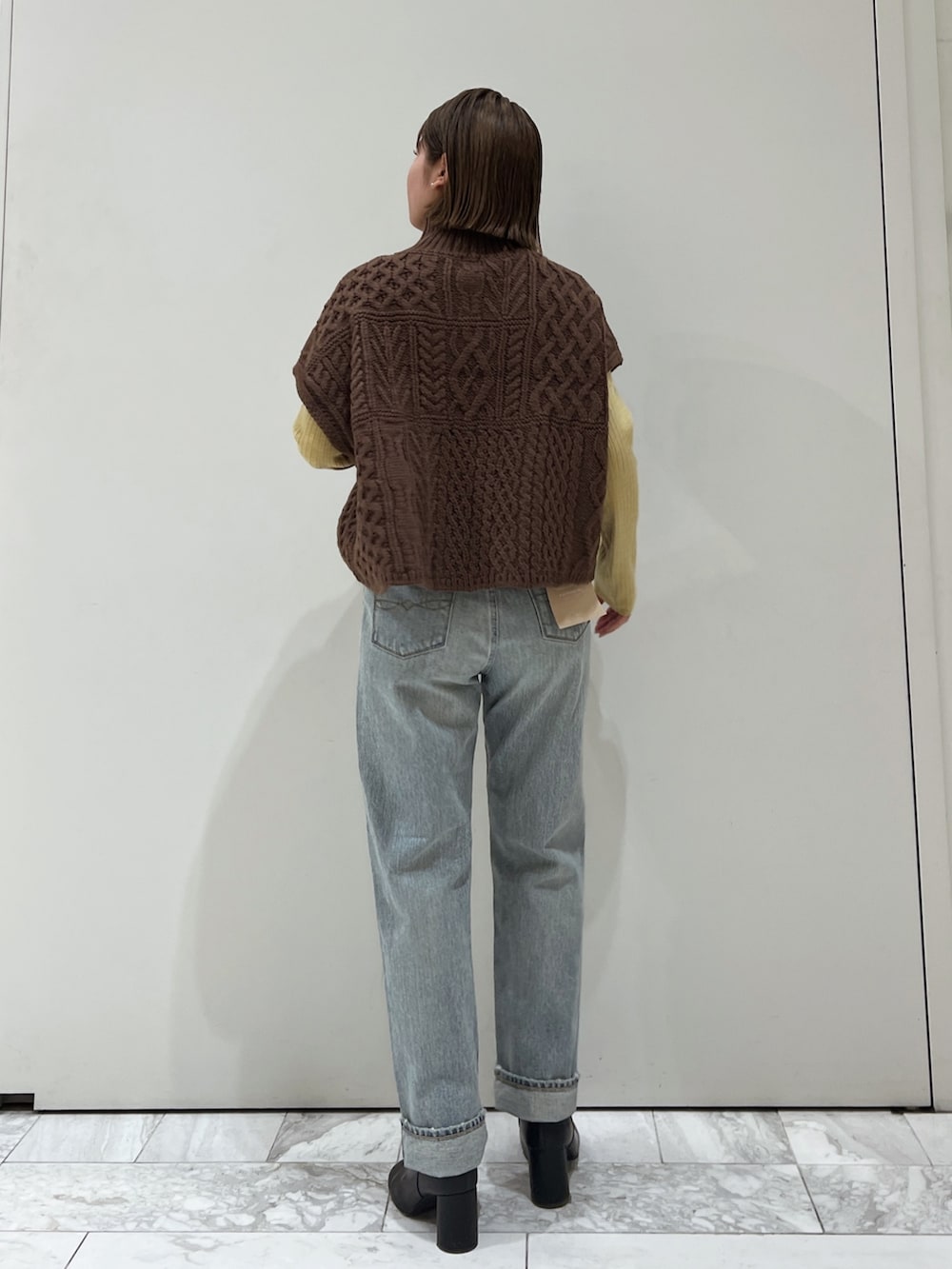 ブラウン系のニット/セーター、ブルー系のデニムパンツ、ブラック系のブーツを着用したレディースの冬コーディネートの4枚目の写真