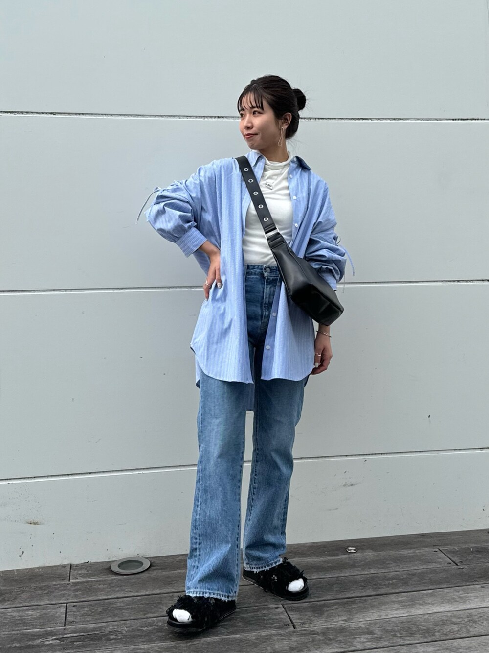 ホワイト系のTシャツ/カットソー、ブルー系のデニムパンツ、ブラック系のショルダーバッグを着用したレディースの冬コーディネートの5枚目の写真