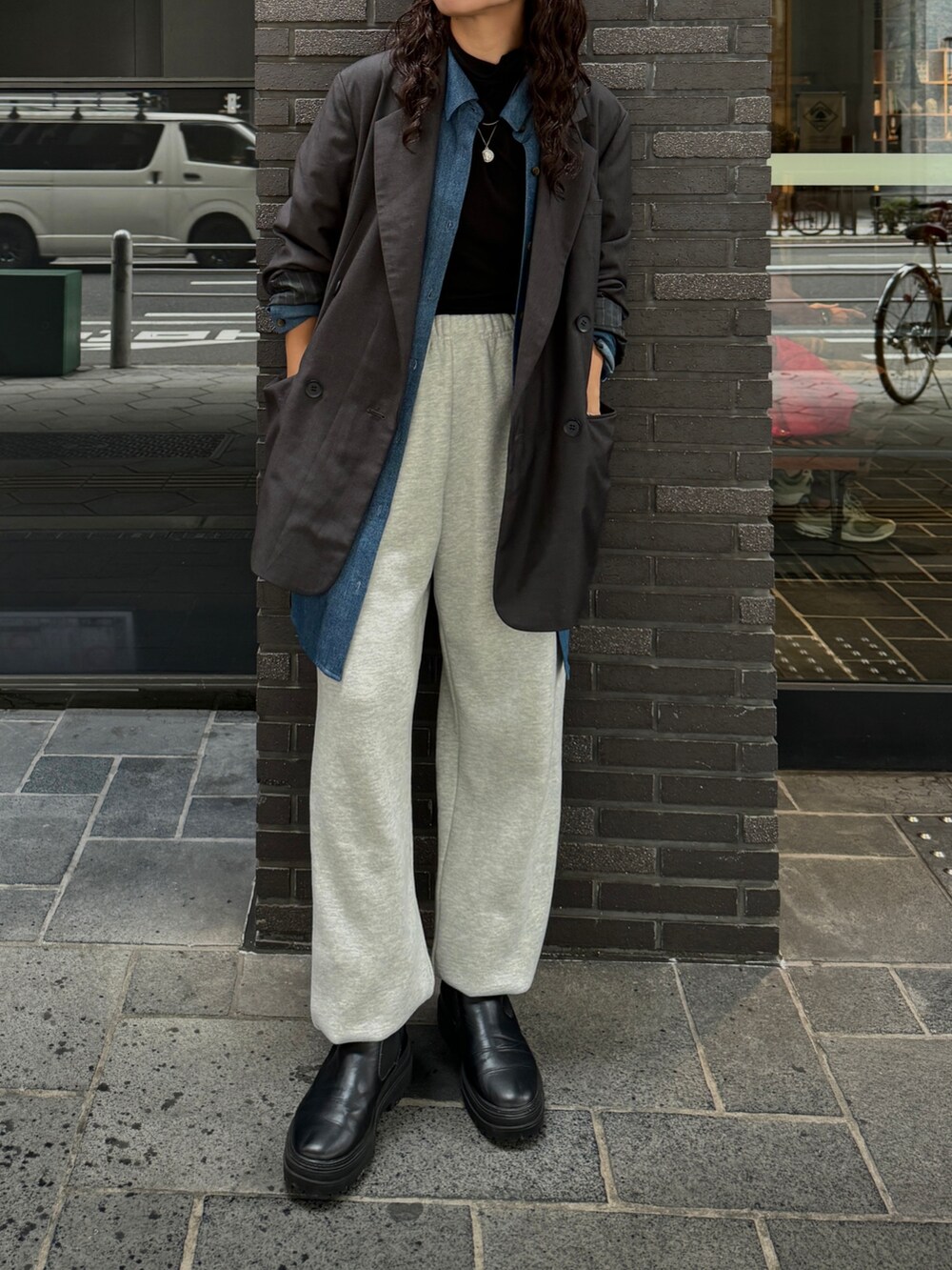 グレー系のスウェットパンツ、グレー系のテーラードジャケット、ブラック系のTシャツ/カットソーを着用したレディースの秋コーディネートの4枚目の写真