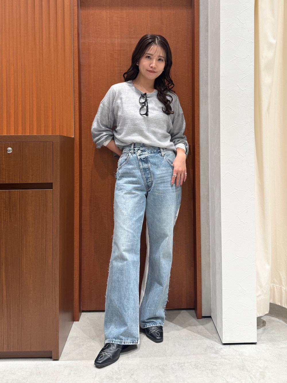 ブルー系のデニムパンツ、グレー系のニット/セーター、ホワイト系のTシャツ/カットソーを着用したレディースの秋コーディネートの5枚目の写真