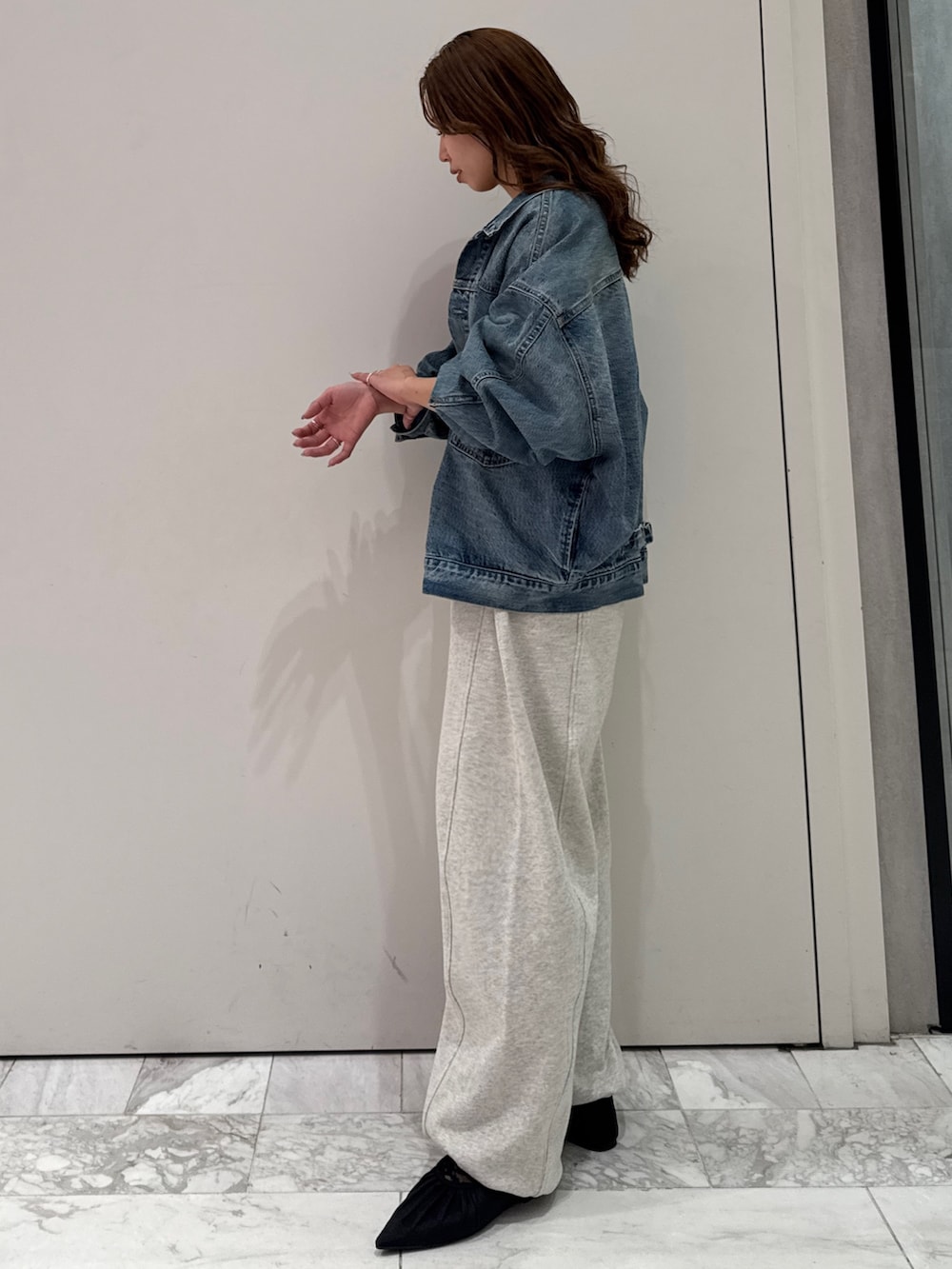 ブルー系のデニムジャケット、ブラック系のカーディガン/ボレロ、ホワイト系のスウェットパンツを着用したレディースの冬コーディネートの5枚目の写真