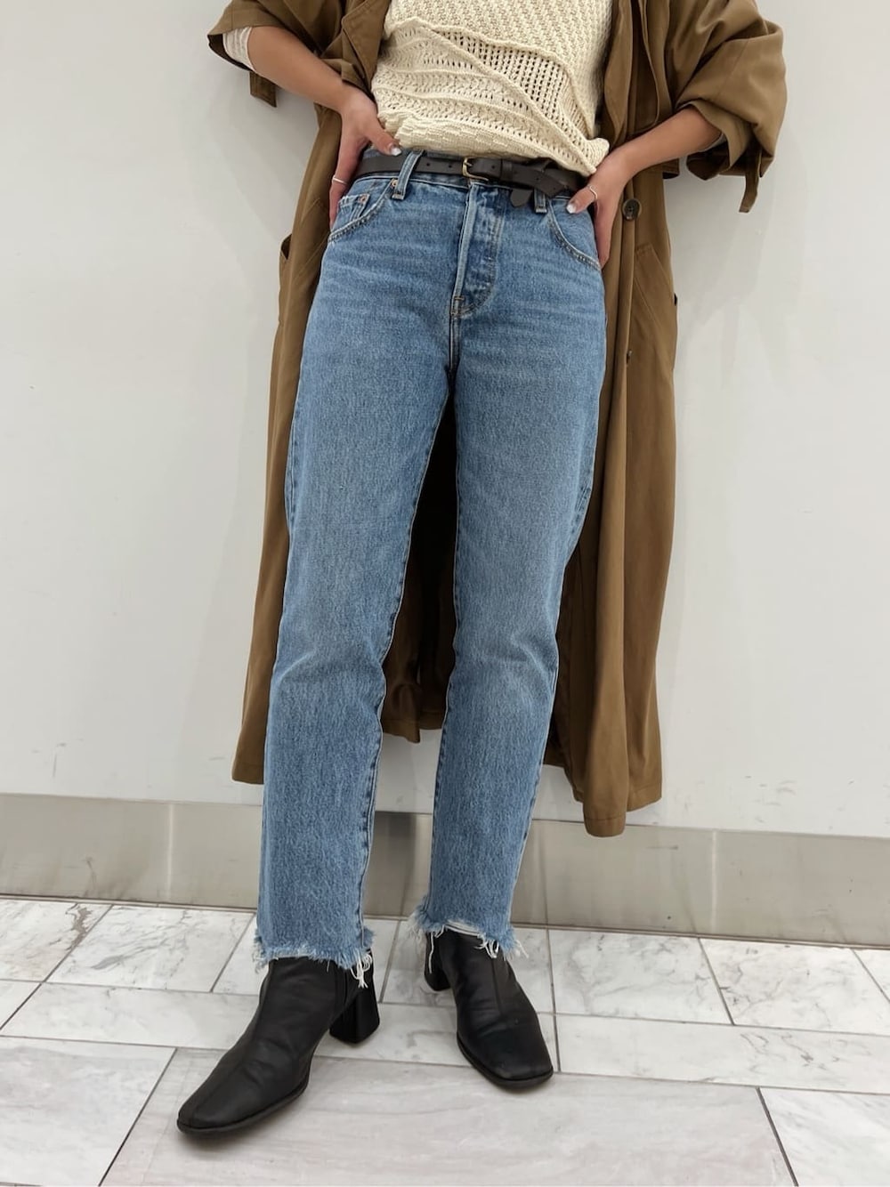 ブラウン系のトレンチコート、ブラック系のブーツ、ホワイト系のニット/セーターを着用したレディースの夏コーディネートの8枚目の写真