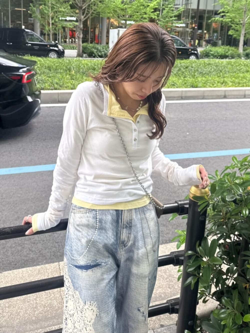 ホワイト系のTシャツ/カットソー、イエロー系のTシャツ/カットソー、ブルー系のデニムパンツを着用したレディースの春コーディネートの5枚目の写真