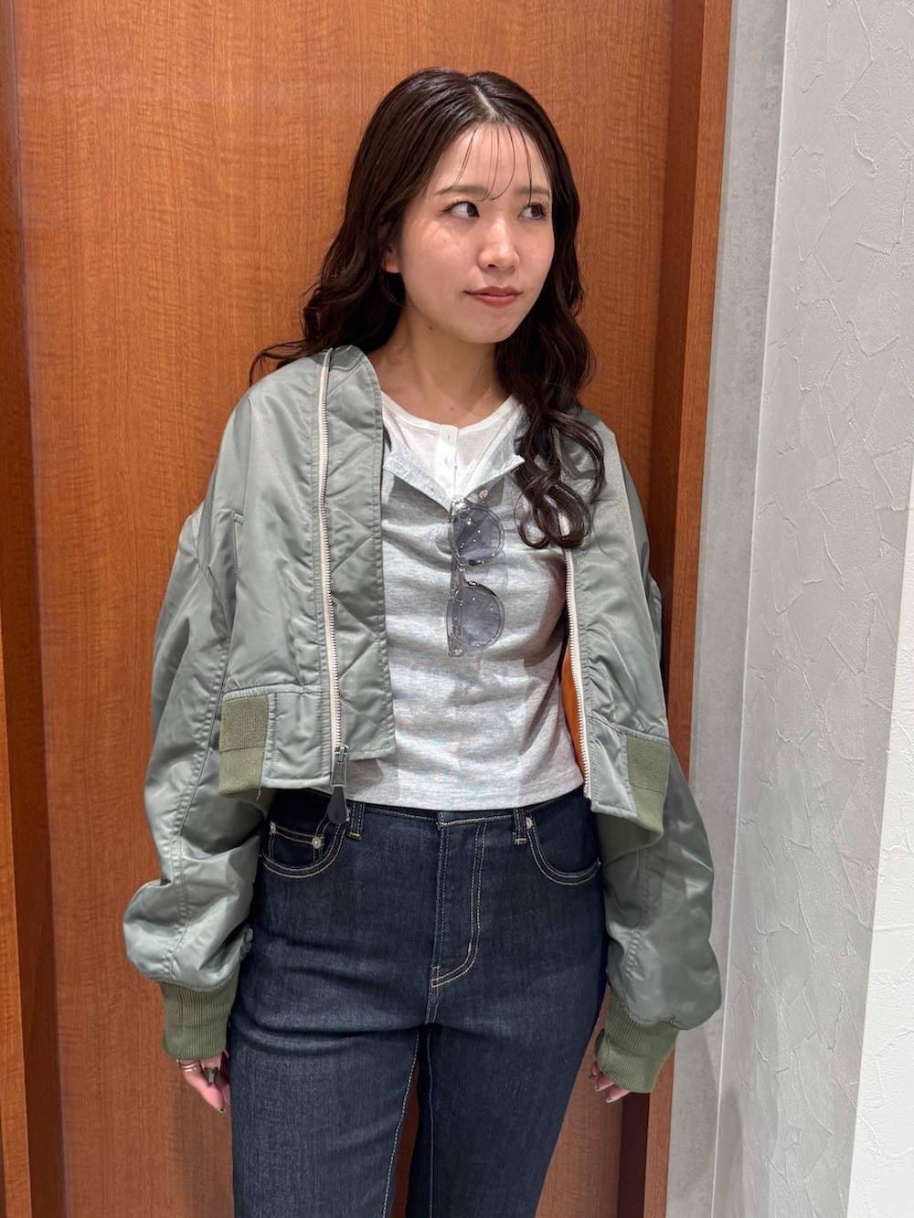 ブルー系のデニムパンツ、グレー系のTシャツ/カットソー、グリーン系のMA-1を着用したレディースの秋コーディネートの6枚目の写真