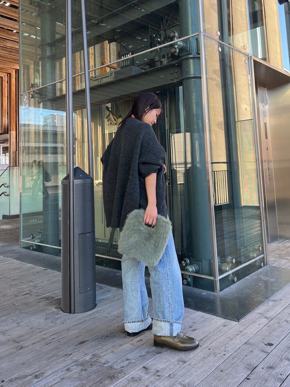 グレー系のカーディガン/ボレロ、ブラック系のキャミソール、ブルー系のデニムパンツを着用したレディースの秋コーディネートの5枚目の写真