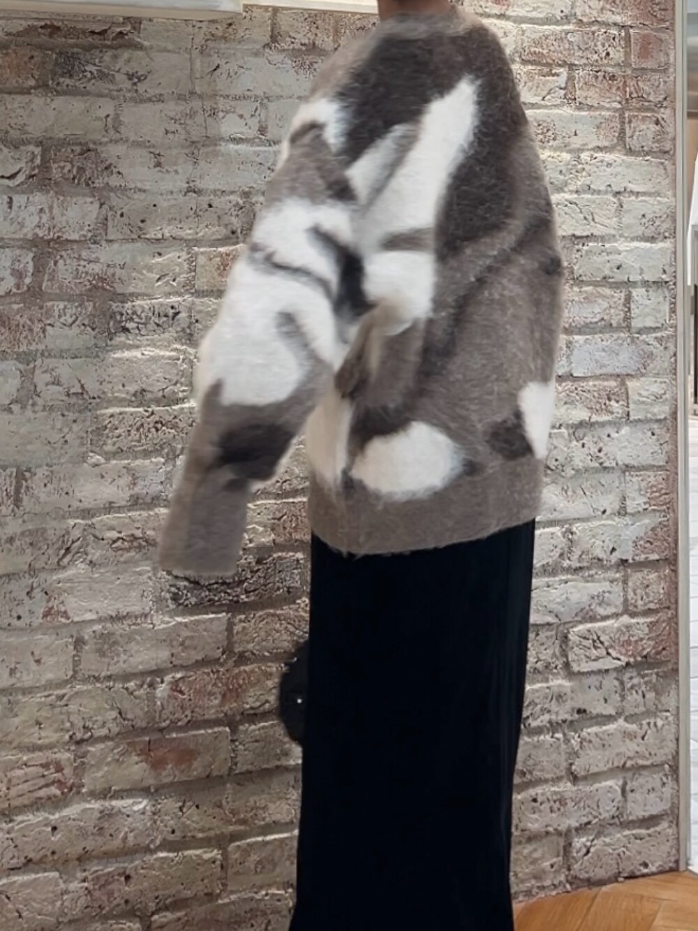 ブラック系のスカート、ブラック系のハンドバッグ、ベージュ系のニット/セーターを着用したレディースの秋コーディネートの5枚目の写真