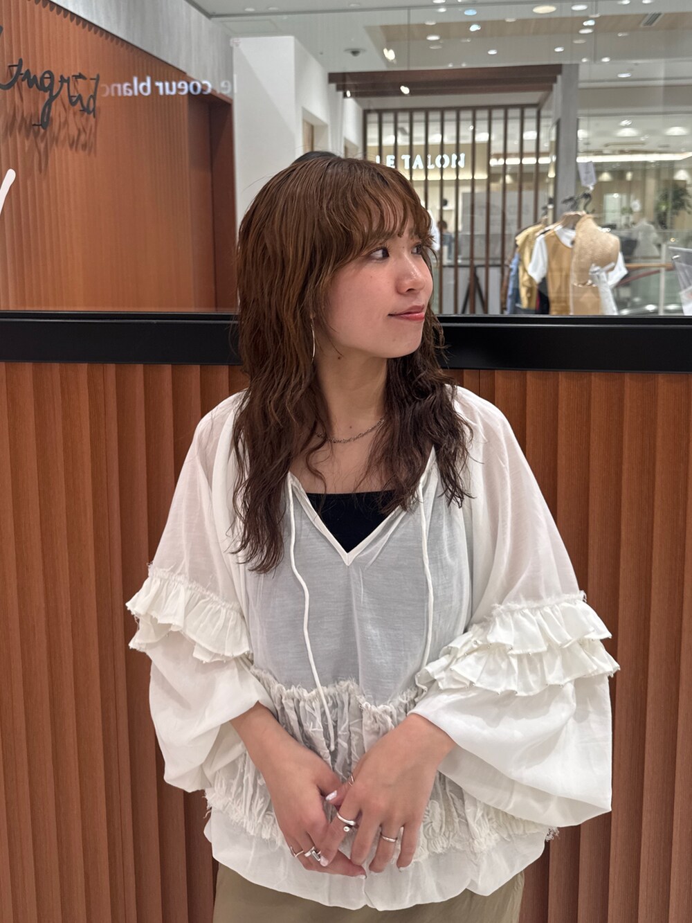 ベージュ系のスカート、ホワイト系のシャツ/ブラウス、ブラック系のキャミソールを着用したレディースの春コーディネートの7枚目の写真