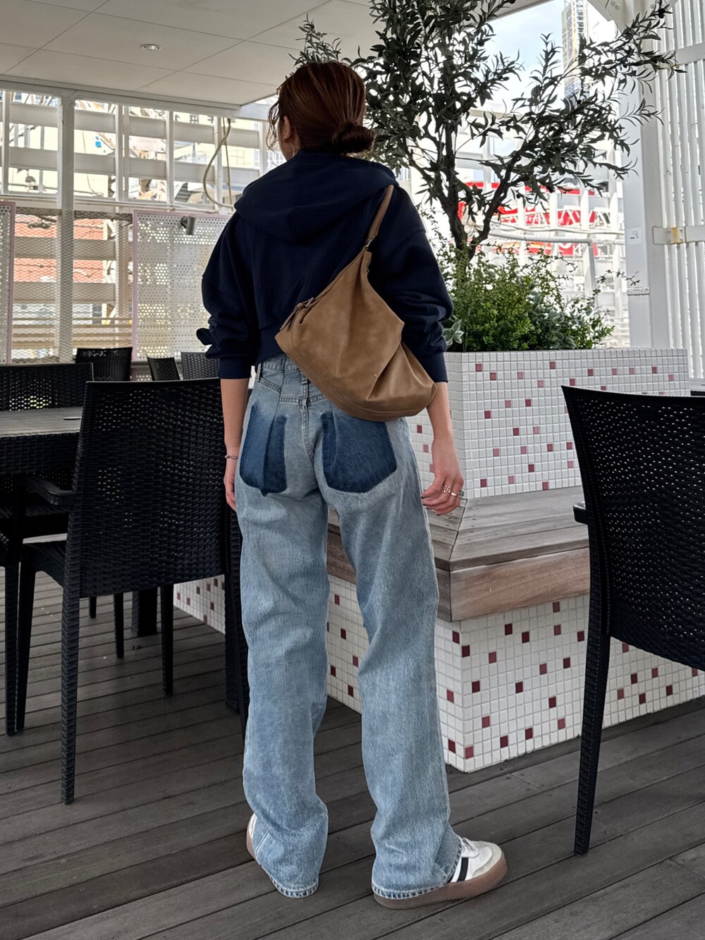 ブルー系のパーカー、ブルー系のデニムパンツ、シルバー系のネックレスを着用したレディースの冬コーディネートの4枚目の写真