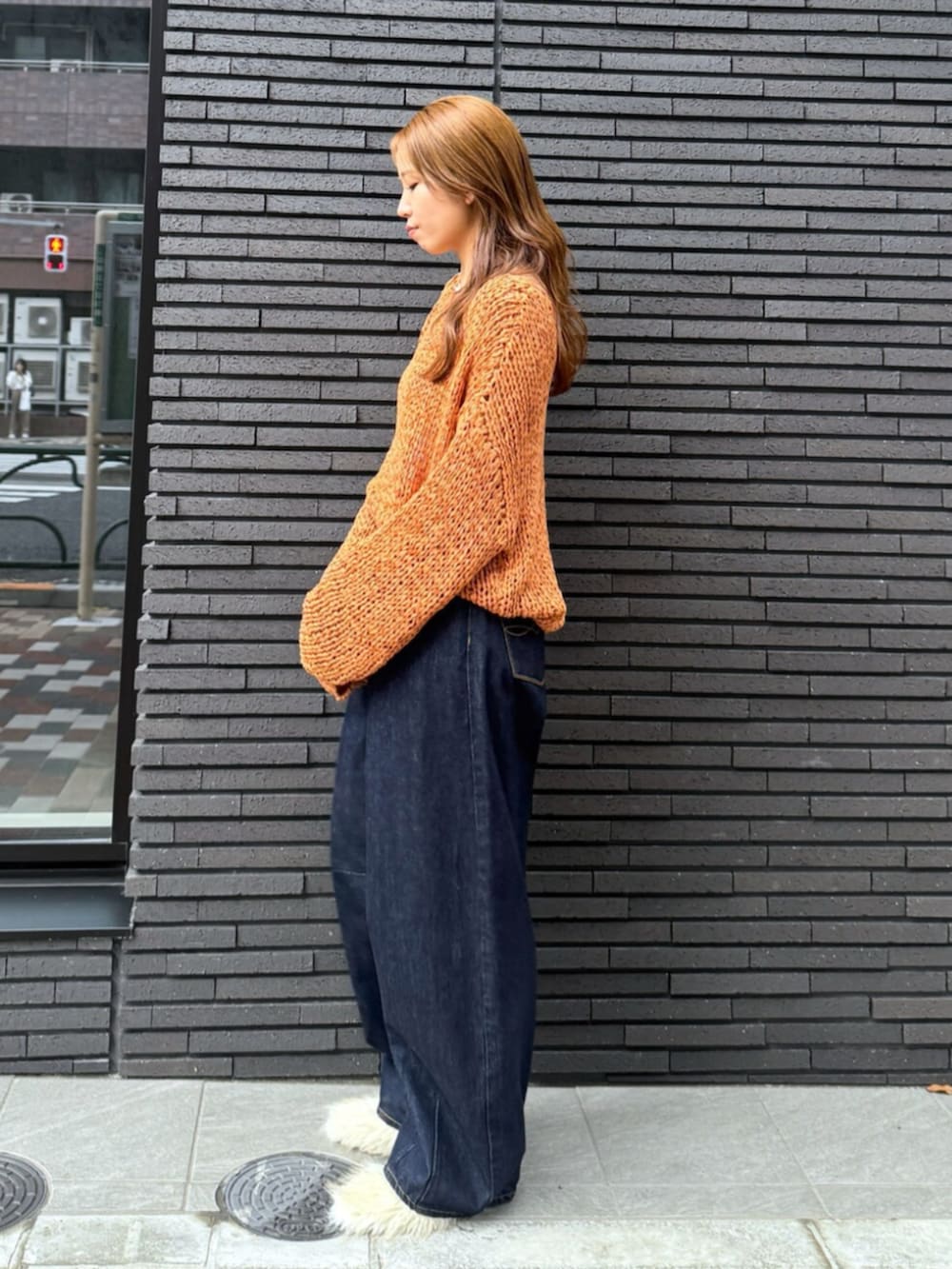 ホワイト系のその他シューズ、ブルー系のデニムパンツ、オレンジ系のニット/セーターを着用したレディースの夏コーディネートの5枚目の写真