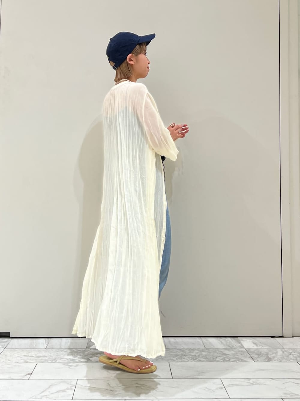 ブルー系のデニムパンツ、グリーン系のサンダル、ブラック系のキャミソールを着用したレディースの夏コーディネートの5枚目の写真