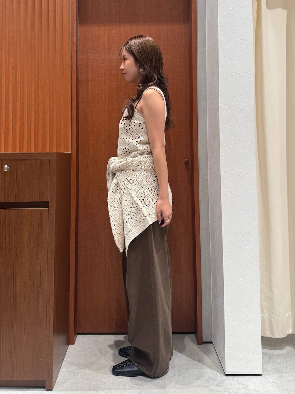 ブラウン系のデニムパンツ、ホワイト系のアンサンブル、ブラック系のその他シューズを着用したレディースの秋コーディネートの4枚目の写真