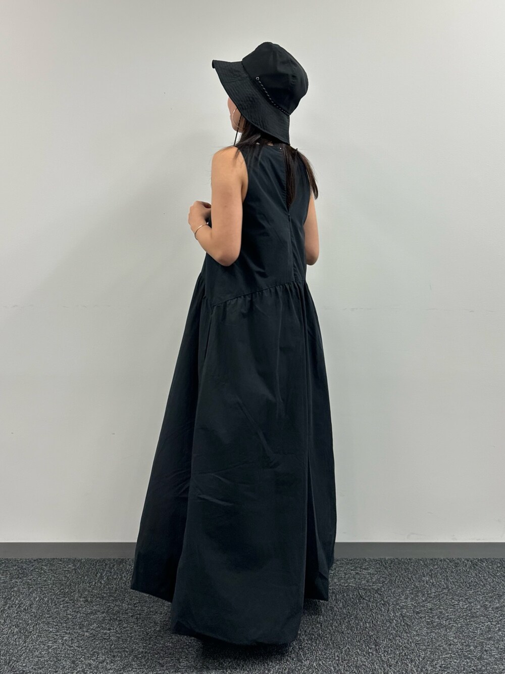 ブラック系のワンピース、ブラック系のハットを着用したレディースの春コーディネートの3枚目の写真