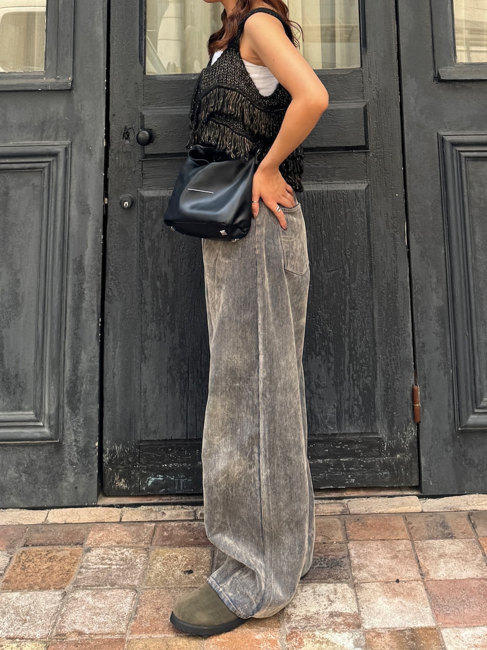 ベージュ系のデニムパンツ、ブラック系のニット/セーター、ベージュ系のスリッポンを着用したレディースの秋コーディネートの3枚目の写真