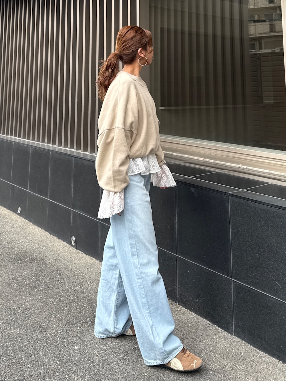 ブルー系のデニムパンツ、ホワイト系のシャツ/ブラウス、ベージュ系のスウェットを着用したレディースの冬コーディネートの2枚目の写真