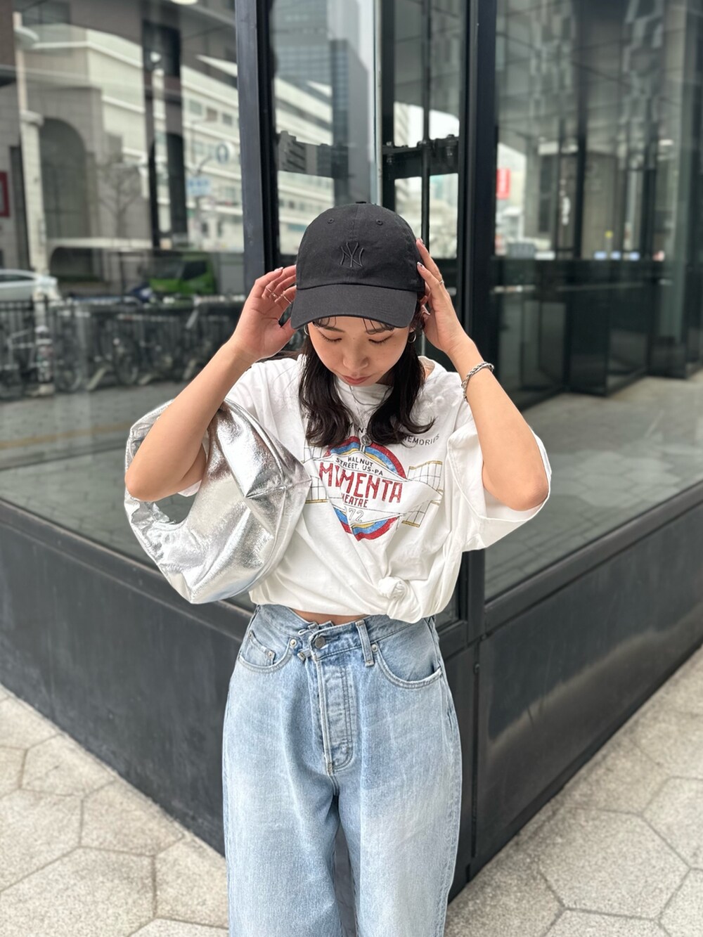 ブルー系のデニムパンツ、ホワイト系のTシャツ/カットソー、シルバー系のハンドバッグを着用したレディースの春コーディネートの8枚目の写真