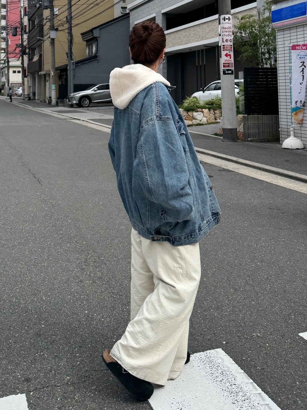 ブルー系のデニムジャケット、ホワイト系のパーカー、ホワイト系のその他パンツを着用したレディースの秋コーディネートの6枚目の写真