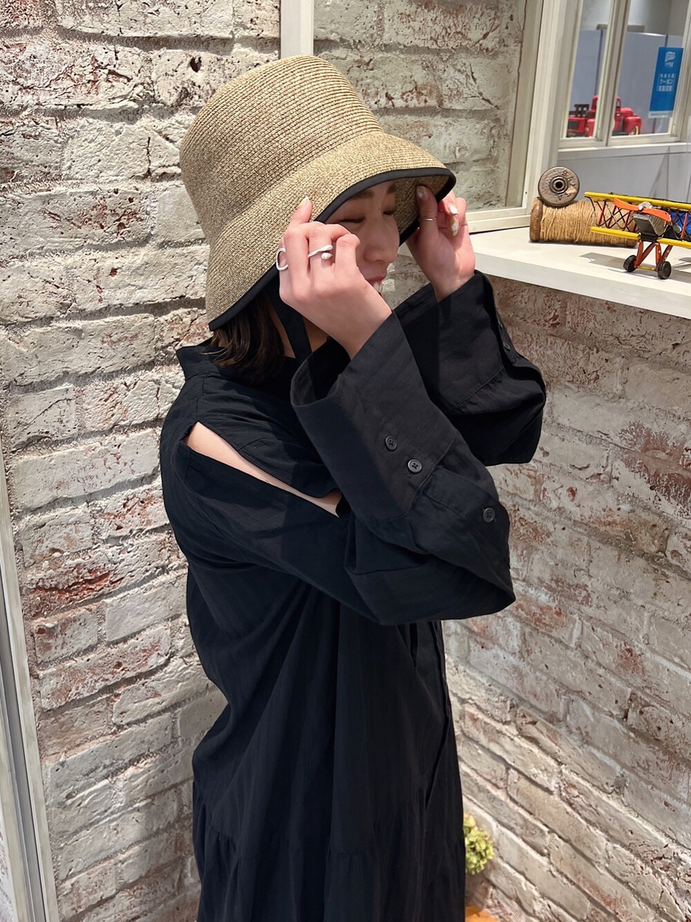 ブルー系のデニムパンツ、ブラック系のサンダル、ブラック系のワンピースを着用したレディースの春コーディネートの10枚目の写真
