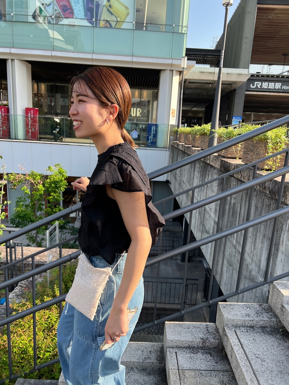 ブルー系のデニムパンツ、ブラック系のパンプス、ブラック系のシャツ/ブラウスを着用したレディースの春コーディネートの7枚目の写真