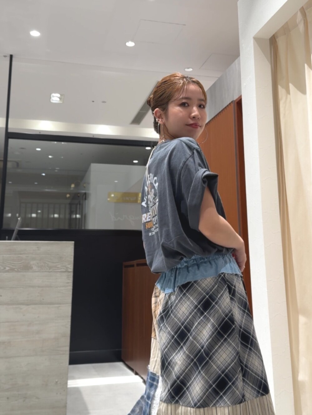 グレー系のTシャツ/カットソー、ブラック系のサンダル、その他のスカートを着用したレディースの春コーディネートの6枚目の写真