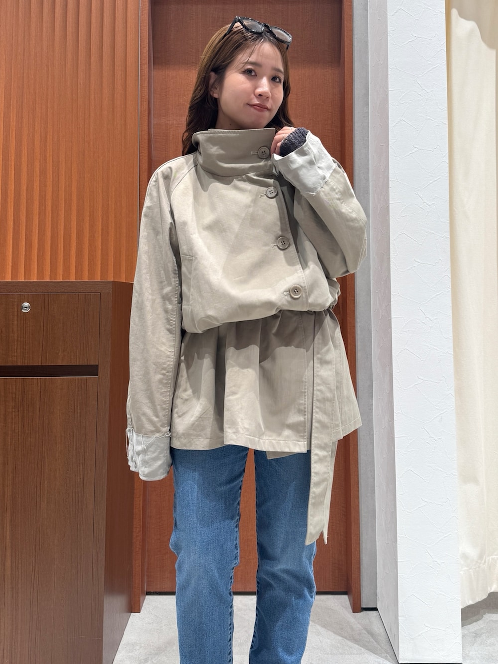 グリーン系のトレンチコート、グレー系のニット/セーター、ブラック系のシャツ/ブラウスを着用したレディースの秋コーディネートの5枚目の写真