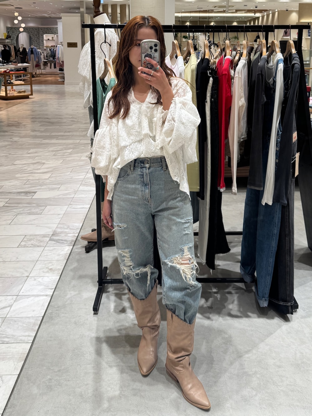 ブルー系のデニムパンツ、ホワイト系のシャツ/ブラウス、ベージュ系のブーツを着用したレディースの春コーディネートの6枚目の写真